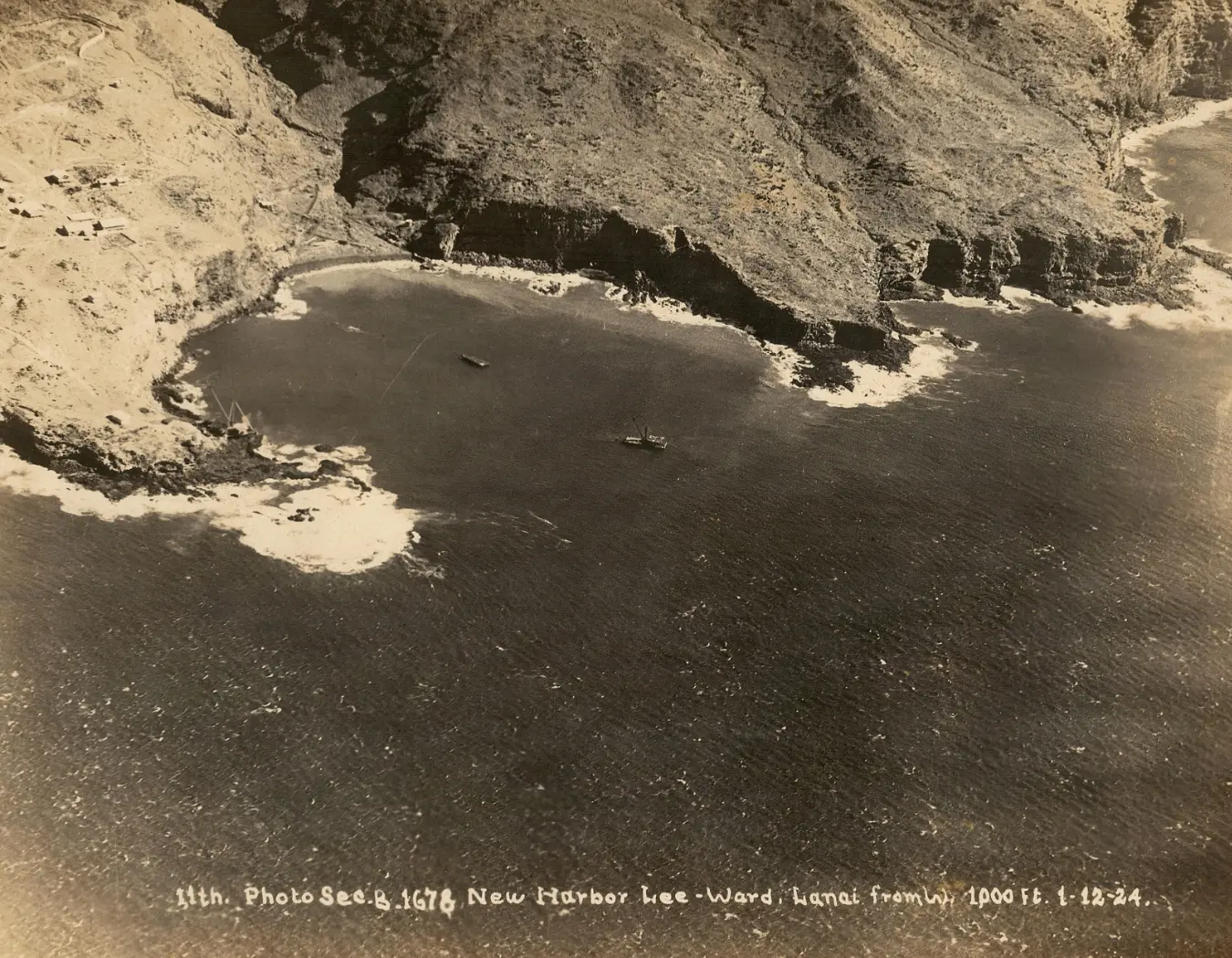 Old photo taken on January 12, 1924, of Kaumalapau Harbor on Lanai. The image shows the harbor with boats docked and the surrounding shoreline, capturing the historical maritime activity and landscape of the area during that time.