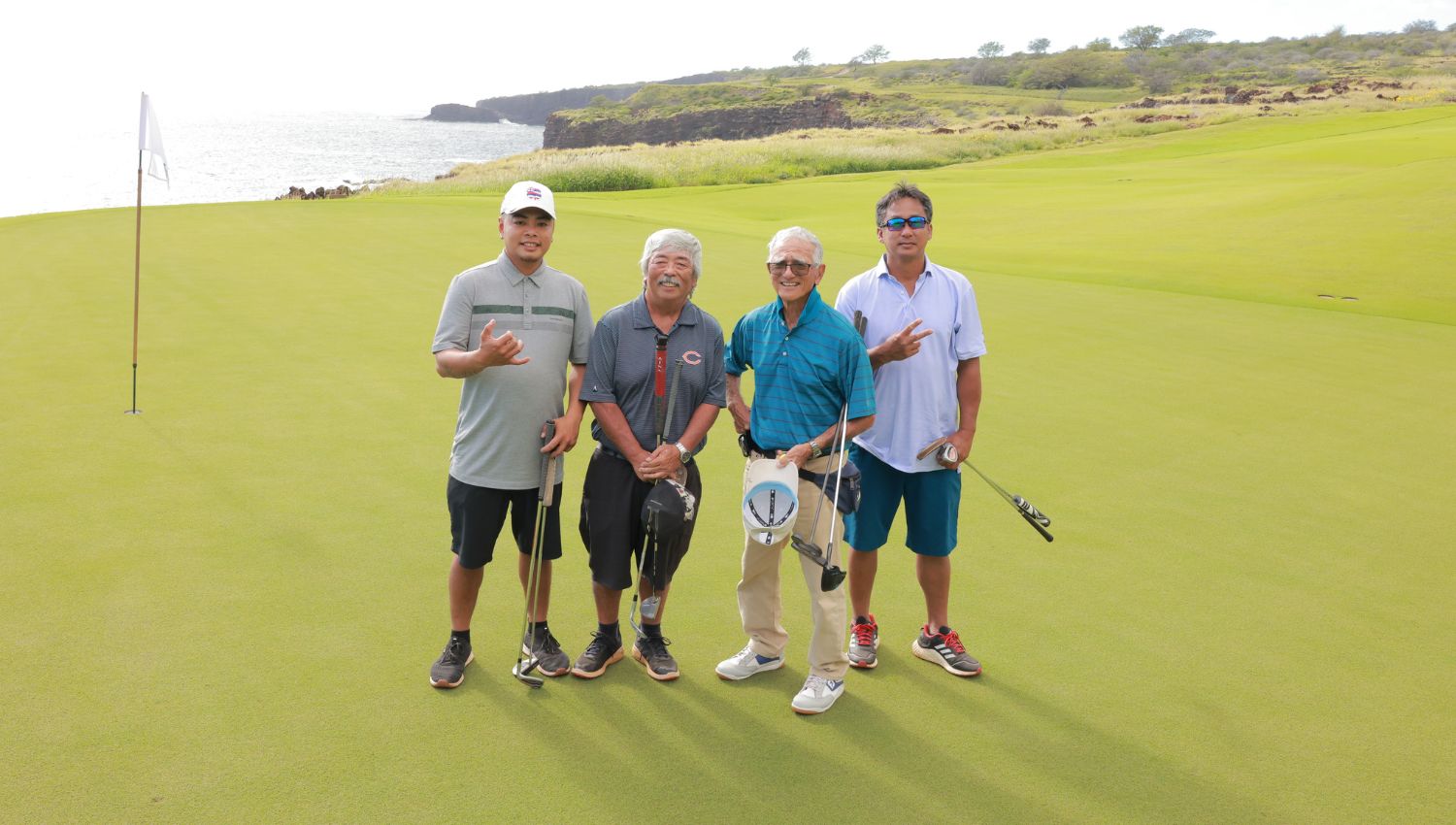 Four men standing together as they look t have finished playing golf in Lanai.