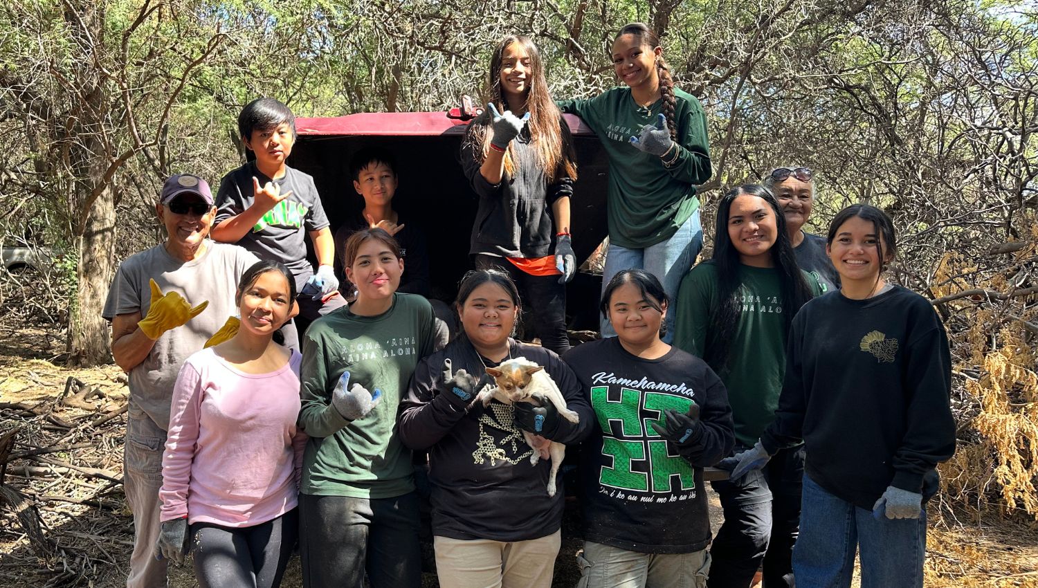 Students smiling together after hard work outside.